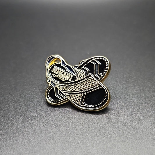 Two pieces of shoe accessories, one in gold and one in silver, with a geometric pattern and the brand 'MIYAGI' inscribed on the gold piece.